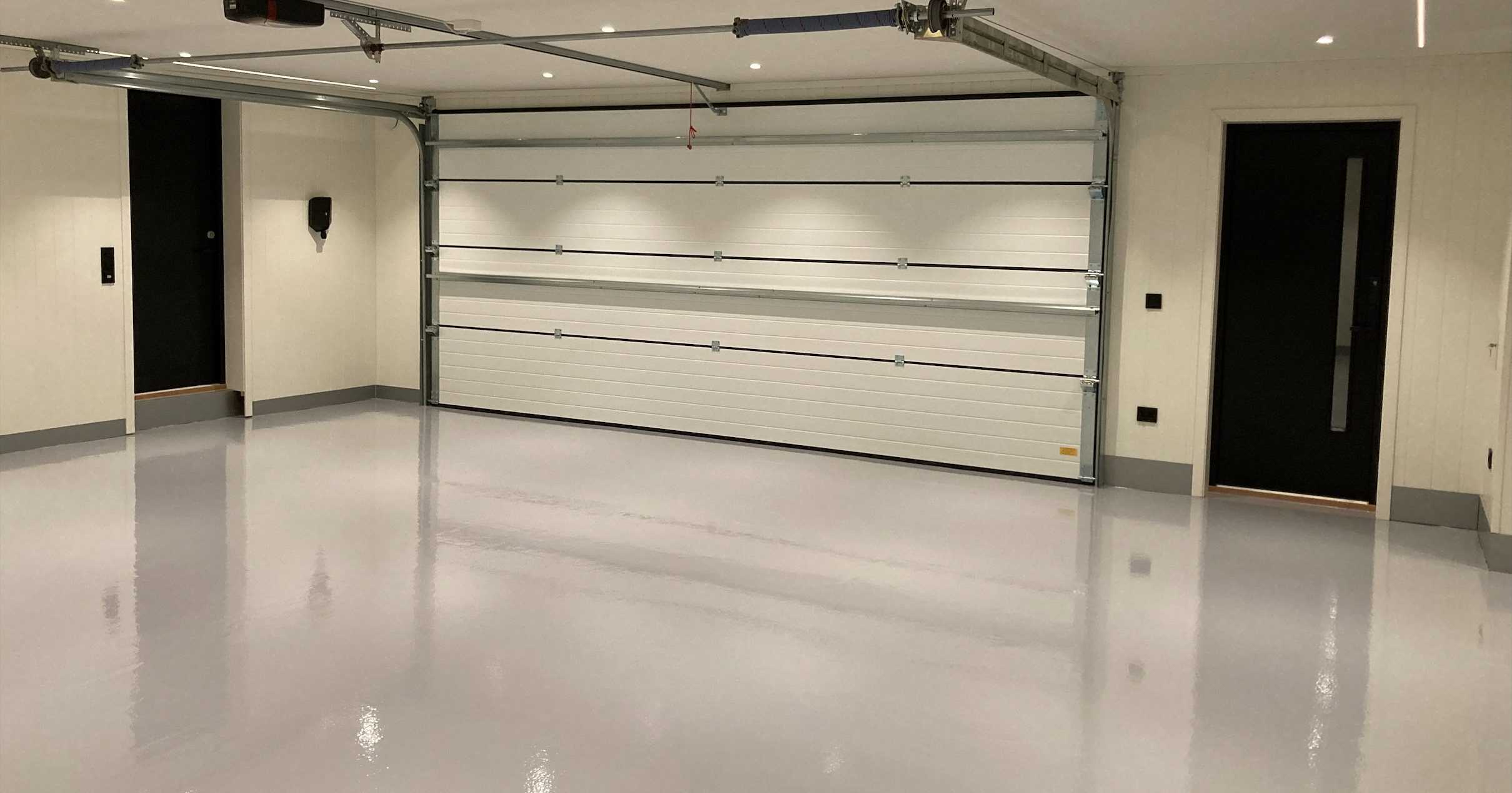 Privat garasje med hvite vegger og lys grått, blankt epoxygulv